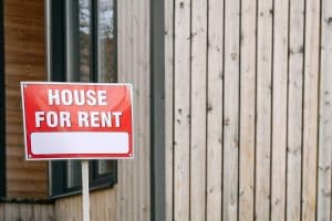 a red sign of a house for rent