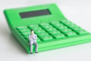 a green calculator with a toy image of a man sitting on it